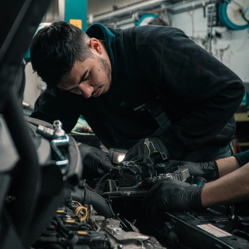 KFZ-Mechaniker von Caplex bei der Arbeit am Motor